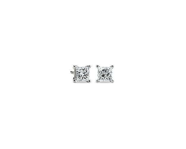 A matched pair of princess cut diamonds are held by platinum prongs. Earrings are finished with guardian backs for pierced ears. Each earring weighs roughly 1/2 carat, for a total weight of 1 carat.