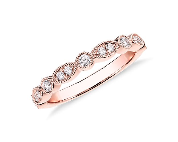 This elegant diamond wedding band stuns with its vintage allure,  featuring a motif of alternating round and marquise shapes and dainty milgrain detailing.