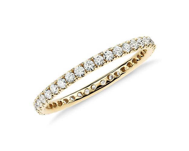 Shimmering round brilliant diamonds encircle this elegant eternity ring designed in 18k yellow gold and featuring pavé-setting.  A petite diamond ring ideal for a wedding band or stacked with other ring styles.