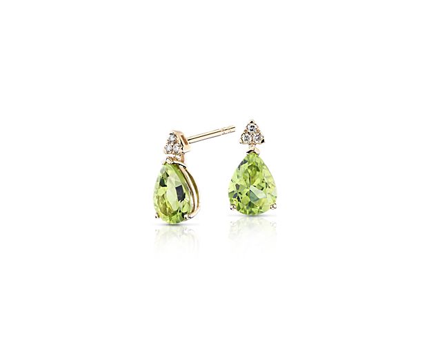 Rich in vivid color, each of these stylish gemstone earrings boasts a single pear-shaped peridot paired with a trio of round-cut diamonds. Set in a drop design setting of warm 14k yellow gold, these earrings are certain to get noticed.