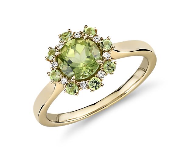 Classic in every way, this peridot and diamond ring features a solitary peridot surrounded by a ring of round diamonds and light-filled peridot gemstones in a 14k yellow gold ring.