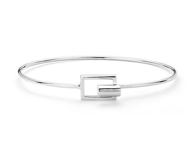 Perfect for a statement look, this geometric bangle bracelet is forged from sterling silver and features a unique clasp for attaching each end of the open bracelet.