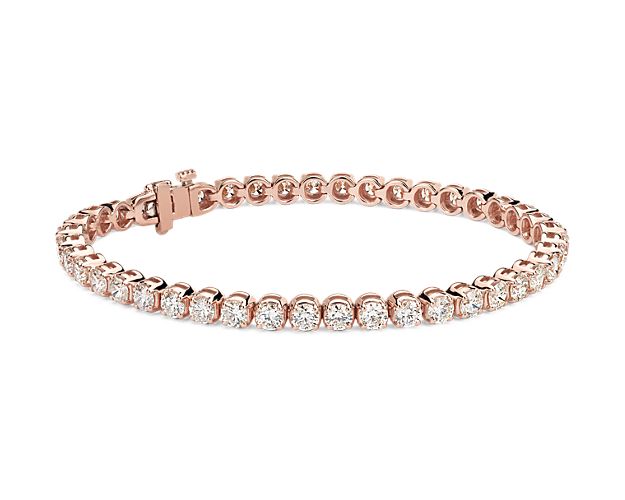 Sparkling, brilliant cut diamonds are set in a classic 14k rose gold, four-prong tennis bracelet.