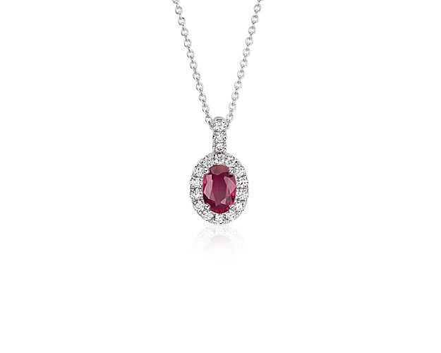 Simply indulgent, this ruby and diamond pendant showcases a rich oval ruby surrounded by pavé diamonds and set in 14k white gold with a matching cable chain.