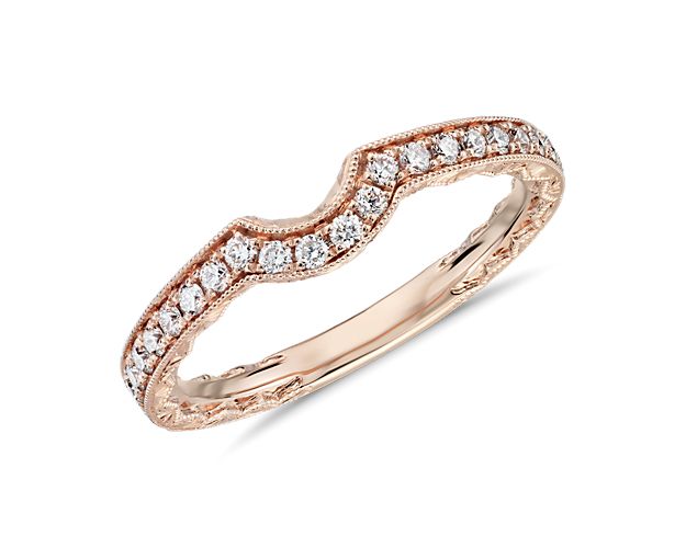 The perfect pair for your engagement ring, this warm, rose gold wedding band accommodates your engagement ring with its gentle curves while showing off its own elegant details, including delicate side décor, milgrain corners and the stunning brilliance of diamond pavé. A perfect match with stock number 71504.