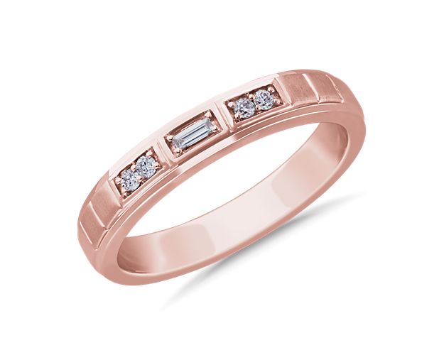 A center baguette diamond is flanked by sparkling round brilliant diamonds in this handsome wedding band. Crafted in 14k rose gold, the geometric accents provide a contemporary appearance.