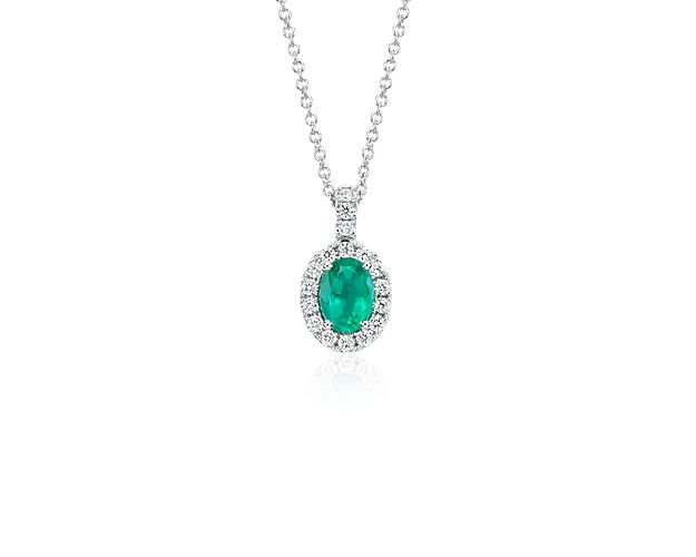 A stunning emerald is surrounded by pavé diamonds in this classic pendant.