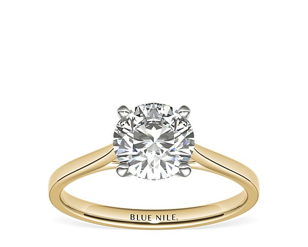 Delicate cathedral shoulders add classic elegance to this petite 14k gold solitaire engagement ring setting.