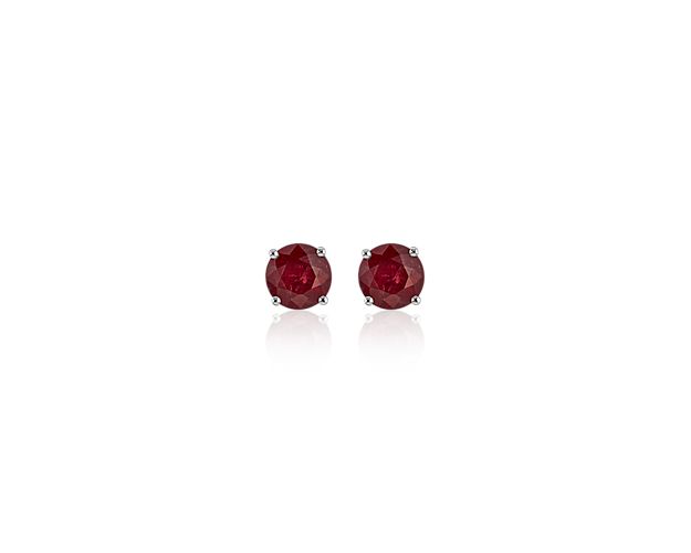 Color outside the lines with these ruby stud earrings. A pair of perfectly matched round rubies in a deep red shade are set in classic 18k white gold four-prong settings perfect for adding personality to your everyday attire.