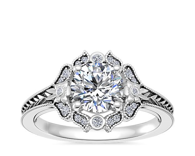 Engraving and milgrain detail bring eye-catching vintage-inspired allure to this 14k white gold engagement ring. The stunning center stone is surrounded by a delicately detailed floral-inspired halo.