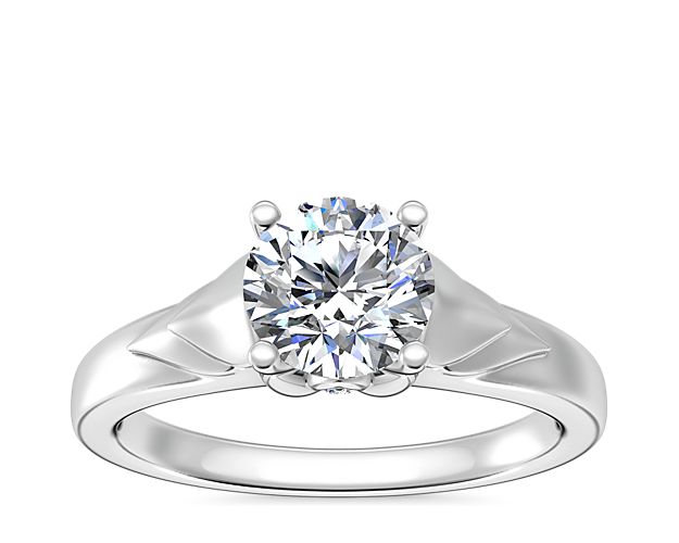 Love shines brilliantly in this solitaire engagement ring featuring a unique chevron design in gleaming 14k white gold. A hidden accent diamond shimmers at the side, adding elegance.