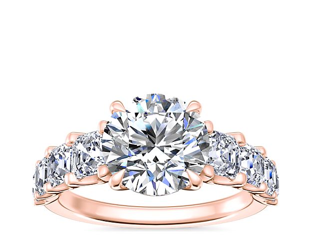 Gorgeously sparkling, this engagement ring features a stunning center stone accented by Asscher-cut side diamonds along the shank. Designed in gleaming 14k rose gold, it promises lasting luxury and beauty.