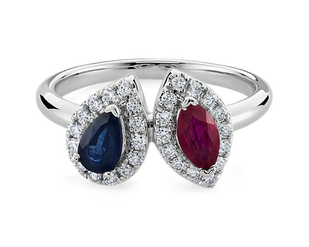 Take their breath away with this stunning two stone ring featuring a pear-cut sapphire and marquise-cut ruby, each surrounded by a brilliant diamond halo. The vibrant stones are complemented by the brightly gleaming 14k white gold.