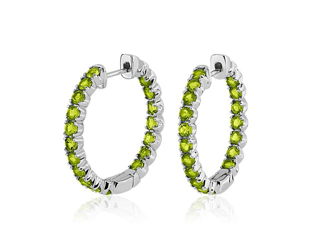Crafted from gleaming sterling silver, these hoop earrings give you a look of bold elegance. The front-facing edges of the hoops are set with brilliant peridot stones that sparkle as the light catches them.
