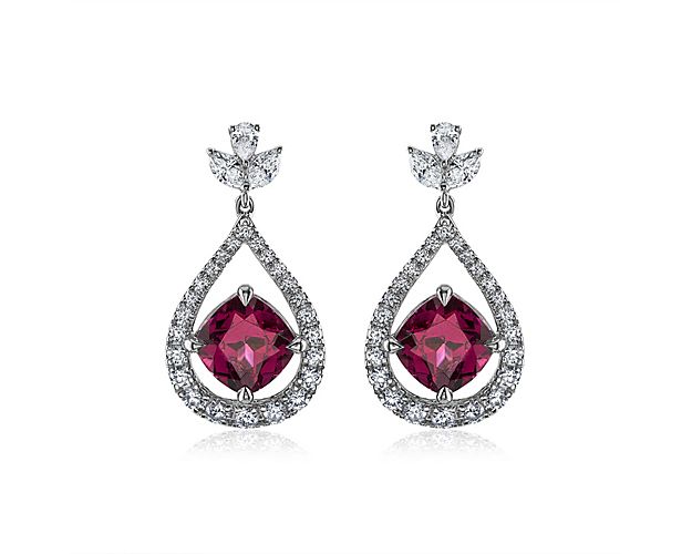 Set in 18k White Gold, these stunning drop earrings feature two cushion cut purple garnets set inside a stunning diamond teardrop shaped design.