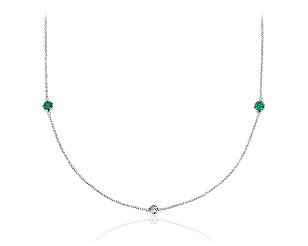 Bezel-set stations of richly hued emeralds and dazzling round-cut diamonds enliven this shimmering 14k white gold necklace.