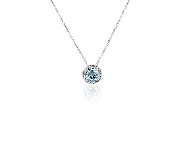 Capture your ray of starlight when layering on this striking 14k white gold pendant necklace. Its perfectly round aquamarine baths in the light of a white diamond halo creating a beautiful interplay of sparkle and color.