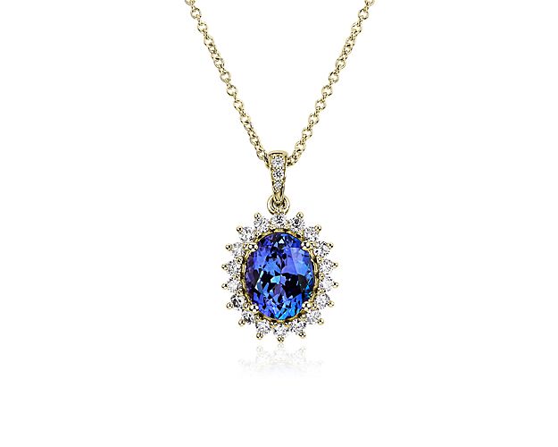A deeply blue oval-cut tanzanite stone nestles at the heart of this pendant, surrounded by a starbust halo of diamonds for a look of regal allure. Warmly lustrous 14k yellow gold beautifully contrasts with the cool hue of the centre stone.