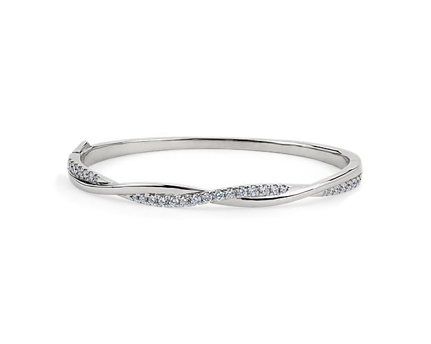 Catch the light when you wear this stunning bangle featuring entwining design in lustrous 14k white gold. One twisting side is set with shimmering diamonds to add gorgeous sparkle to your wrist.