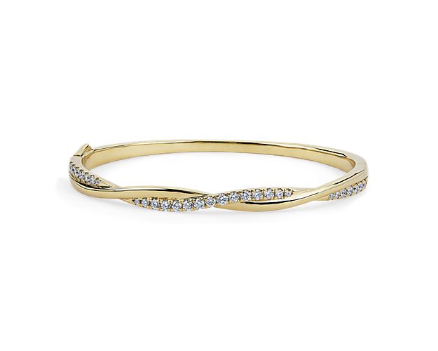 Opt for elegant style with this slender bangle crafted in gleaming 14k yellow gold. The twisting design features one strand set with shimmering diamonds, beautifully wrapped around one plain strand for eye-catching effect.