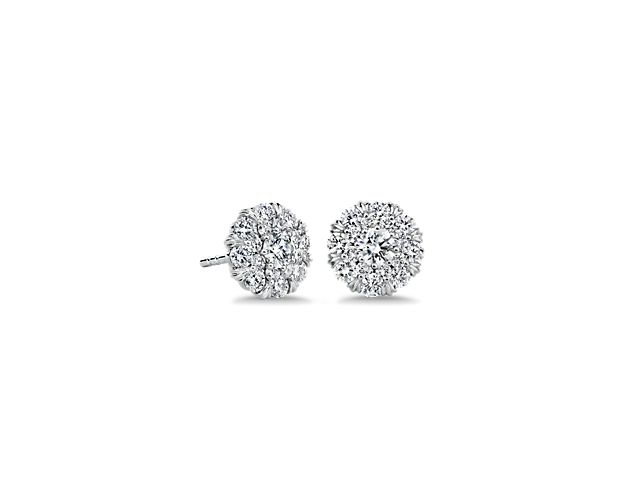 These timelessly elegant stud earrings feature a gorgeous round centre diamond, surrounded by a shimmering double halo of diamonds. The cool, luxurious gleam of the 14k white gold design finishes the style.