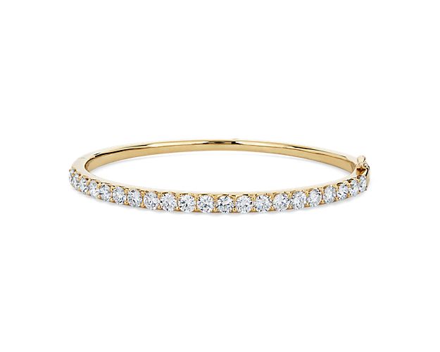 Add gorgeous gleam to your wrist with this round bangle bracelet crafted from warmly lustrous 14k yellow gold. Brilliant lab-grown diamonds encircle the bracelet, adding sparkling luxury.