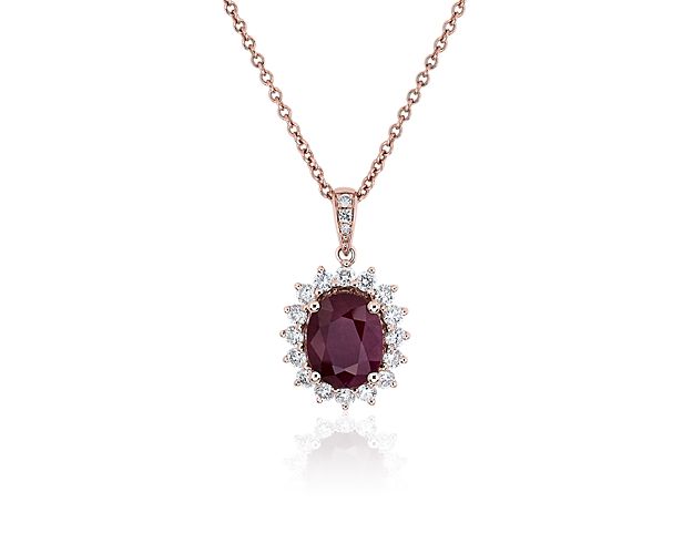 A rich red ruby gleams at the heart of this stunning pendant, while a diamond starburst halo adds vivid sparkle. The warm gleam of the rose gold chain complements the dramatic stone.