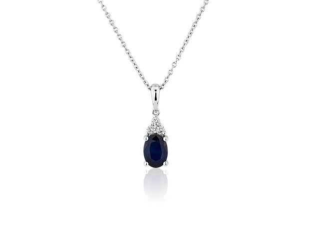 Bring a brilliant finish to your style with this stunning pendant necklace featuring an oval-cut sapphire with a shimmering cluster of accent diamonds. The cool lustre of the white gold design completes it with the promise of enduring luxury and quality.