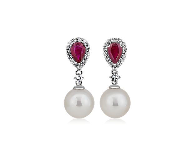 Summon their eye when you wear these stately drop earrings, each featuring a lustrous Akoya pearl dangling gracefully. The posts are set with vibrant red rubies, accented by shimmering diamond halos.