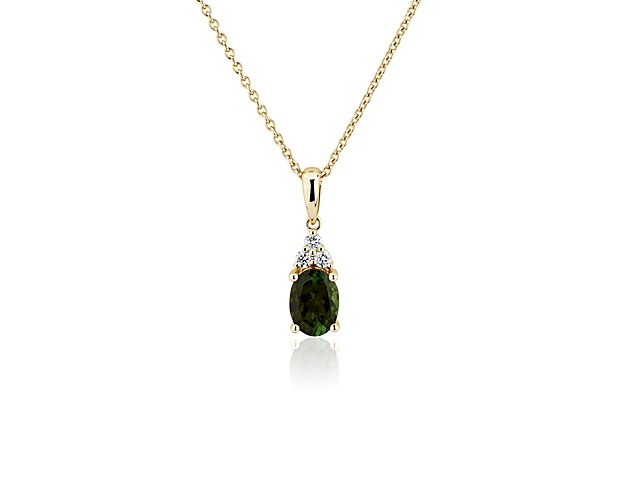 This timelessly elegant pendant necklace is defined by a stunning oval-cut green tourmaline stone, beautifully accentuated by a cluster of delicate accent diamonds. It is designed in lustrous 14k yellow gold that complements the hue of the centre stone.