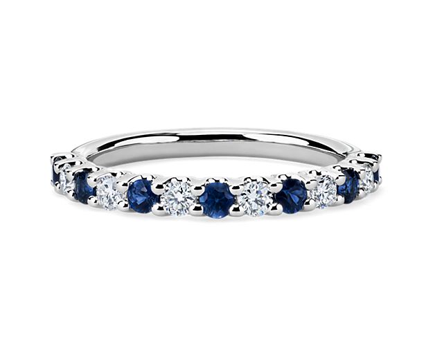 Shared prongs with a draped side profile showcase alternating diamonds and deep blue sapphires for a modern, timeless look.