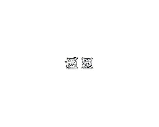 A matched pair of lab grown princess cut diamonds are held by platinum prongs. Earrings are finished with double-notch friction backs for pierced ears. Each earring weighs roughly 1/4 carat, for a total diamond weight of 1/2 carat.