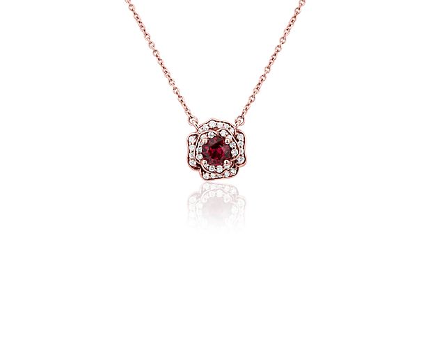 Inspired by the beauty of nature, this pendant features a rose-inspired design in 14k rose gold, with a brilliant red ruby at the heart of the flower. Diamonds are delicately set into the petals surrounding the center stone for a double halo effect.