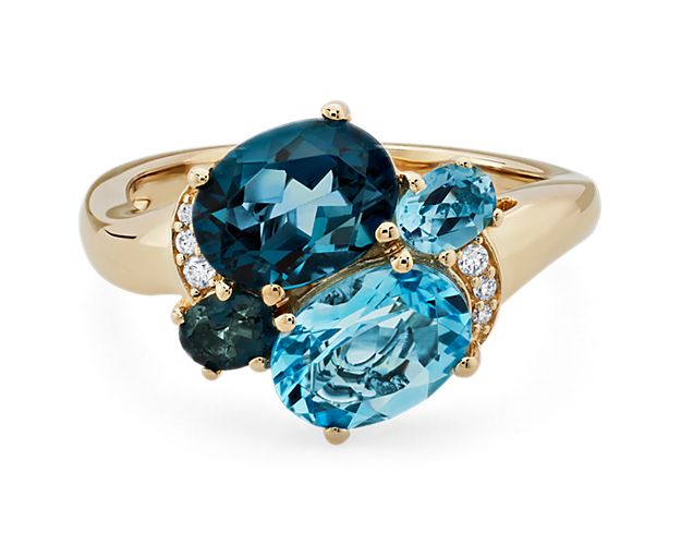 Expertly crafted from luxurious 14k yellow gold, this ring features an exquisite  London Blue Topaz gemstone as well as a mesmerizing Swiss Blue Topaz gemstone. To add even more opulence, this ring also features delicate diamond accents that wrap around, glistening in the light with every movement
