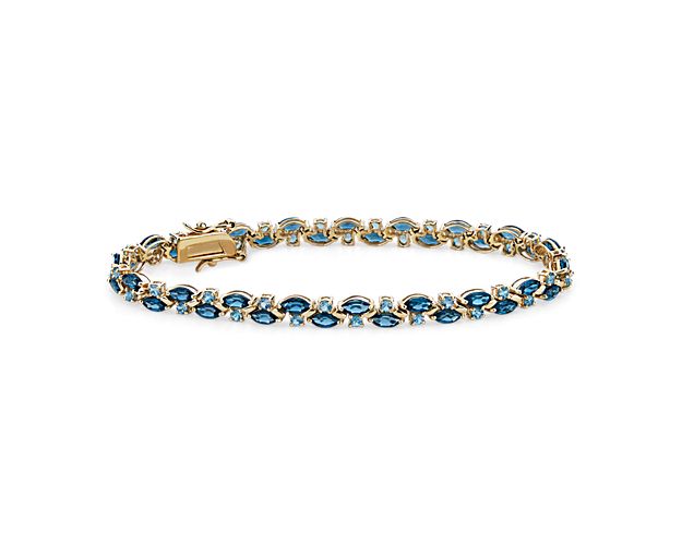 Gorgeous marquise-cut London blue topaz and delicate round-cut Swiss blue topaz stones shimmer along this bracelet in an elegant pattern. Warmly gleaming 14k yellow gold design adds a beautiful contrast to the cool tones of the stones.