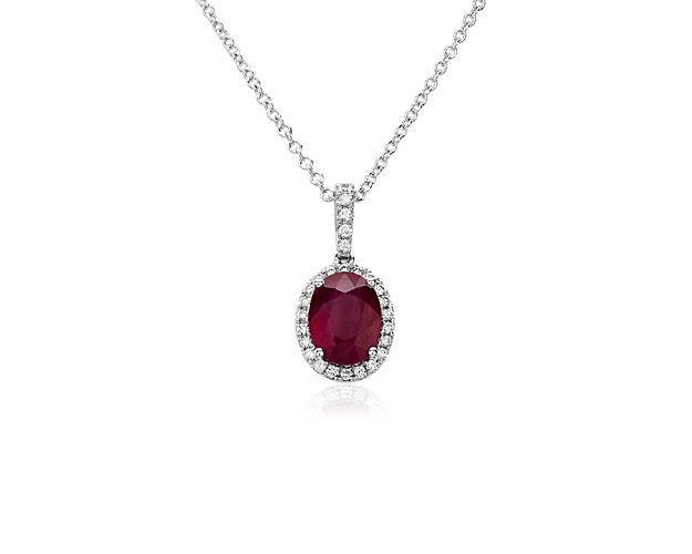 This stunning pendant necklace features a vividly red ruby nestled in a halo of micropavÃ© diamonds. The 14k white gold design promises lasting lustre and quality, and features delicate diamonds accenting the bale.