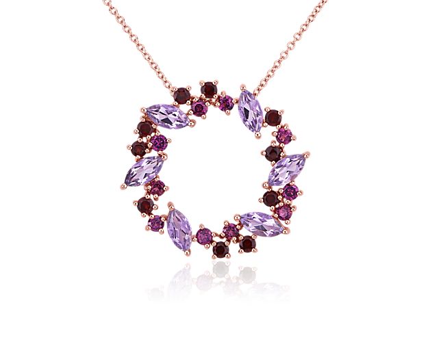 Brilliantly shimmering, this wreath-shaped pendant is set with a stunning array of marquise-cut amethysts and round-cut rhodolite stones. The rich hues of the stones are complemented by the warm romance of the 14k rose gold setting.