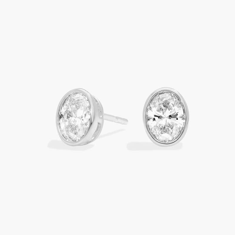 Bezel Diamond Stud Earrings With 0.75 CTW Oval Cut Diamonds in Platinum