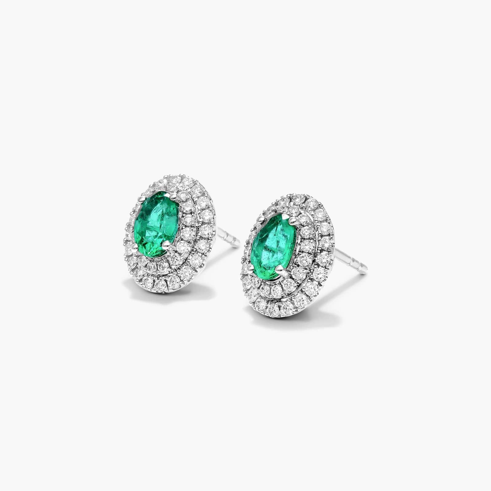 Oval Cut Emerald And Diamond Double Halo Earrings In 18K White Gold