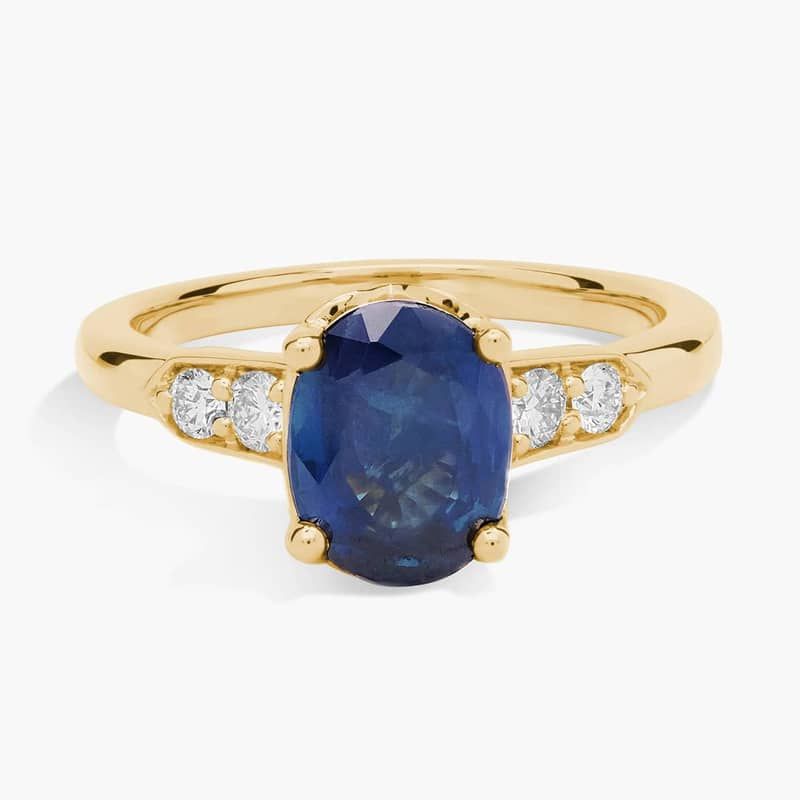 Oval Sapphire and Diamond Side Stone Ring in 14k Yellow Gold (9x7mm)