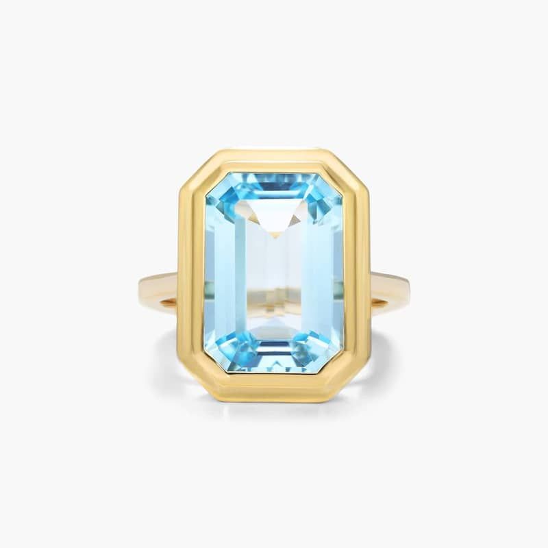 Emerald Cut Bezel Sky Blue Topaz Cocktail Ring In 18K Yellow Gold