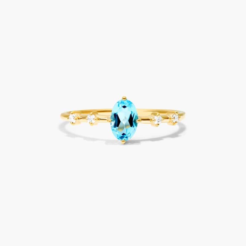Oval Blue Topaz And Diamond Birthstone Ring In 14K Yellow Gold